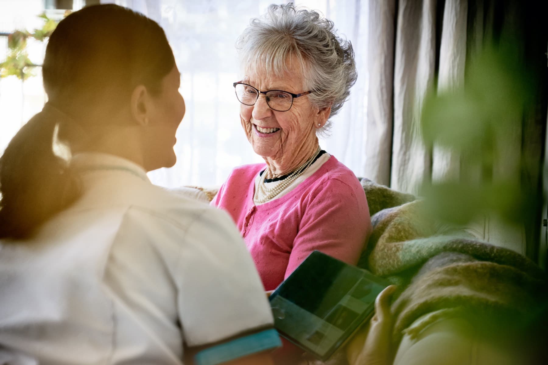 Oceania resident smiling at a Oceania healthcare assistant