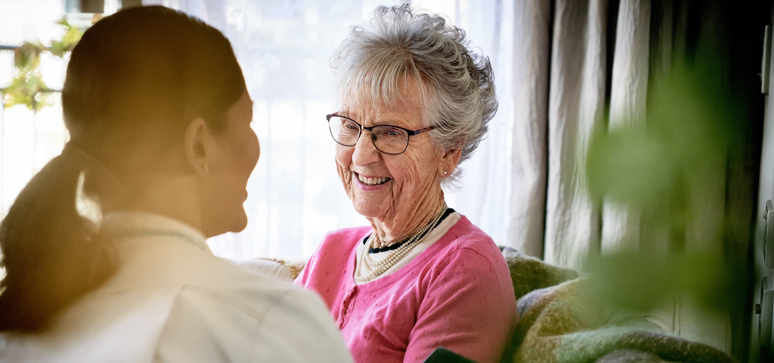 Oceania resident smiling at a healthcare assistant